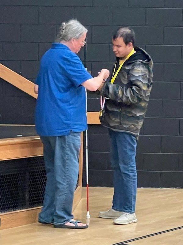 male student receives medal and ribbon