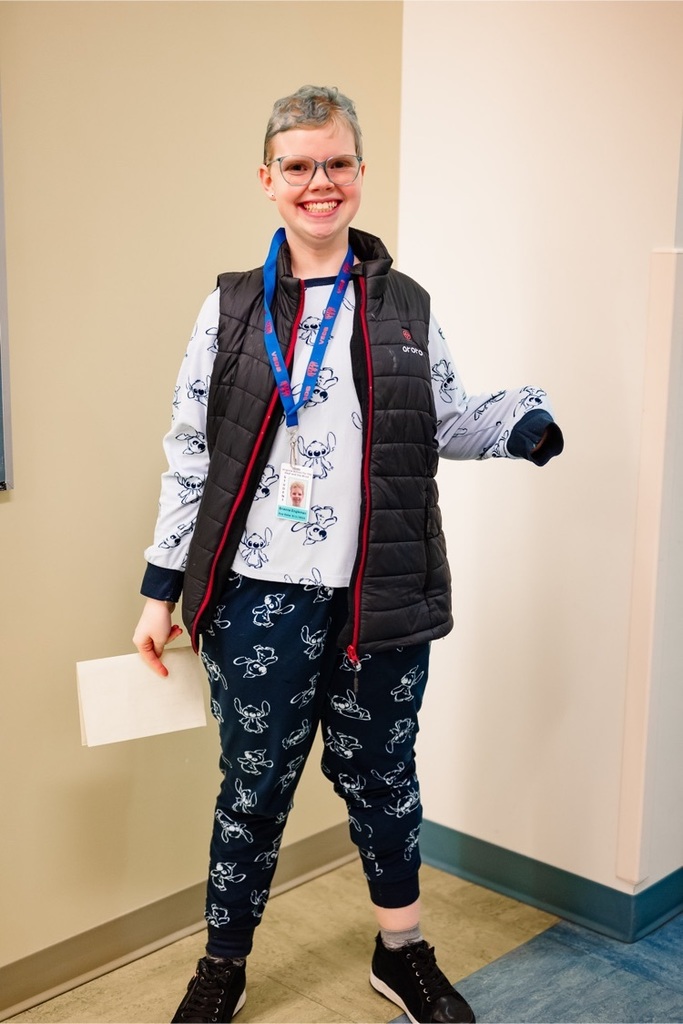 female student stands and smiles wearing her pajamas