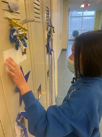 female student reading the Braille note attached to her decorated locker