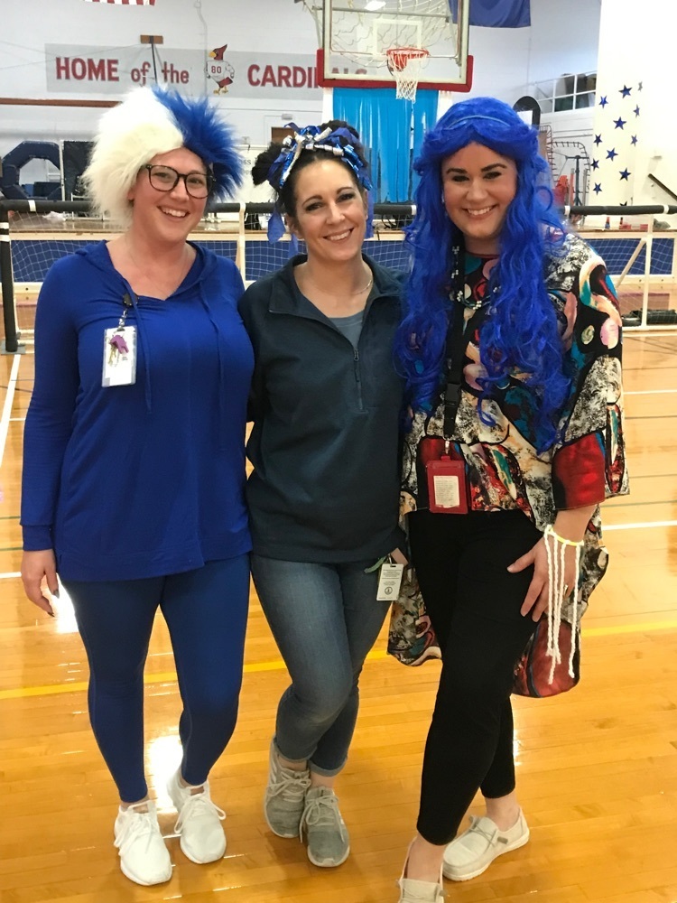 three staff covered head to toe in blue. two wearing wigs and one with blue ribbons in her hair  