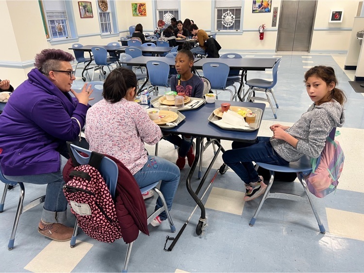 female staff sitting at a table with two deaf students and one blind student, signing mom