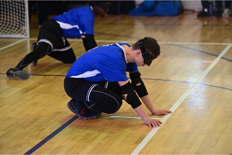 two male Goalball players stretching 