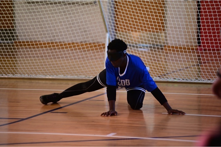 male Goalball player ready to block a ball