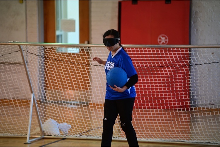 female Goalball player ready to throw the ball