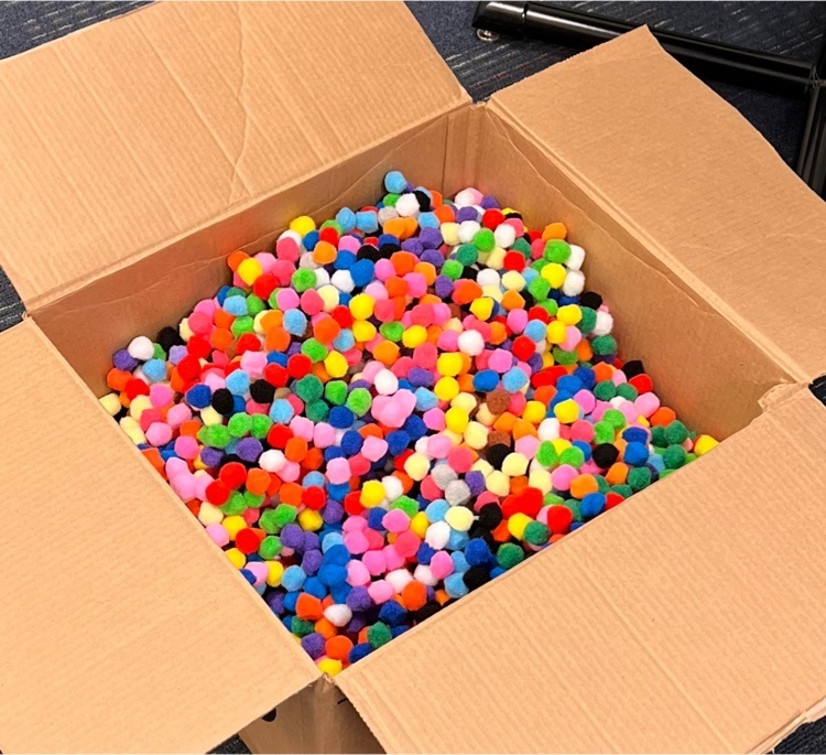cardboard box full of multicolored pompom balls