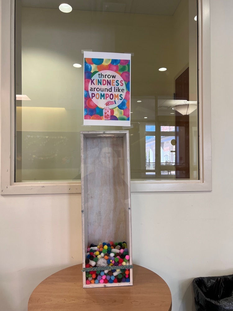 tall rectangular container is about 1/4 full of pompoms