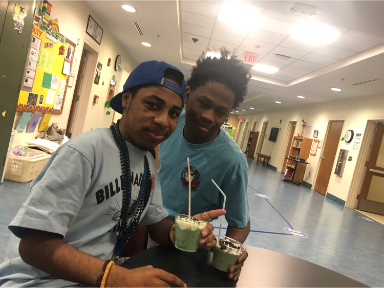 two male students pose with their shamrock shakes