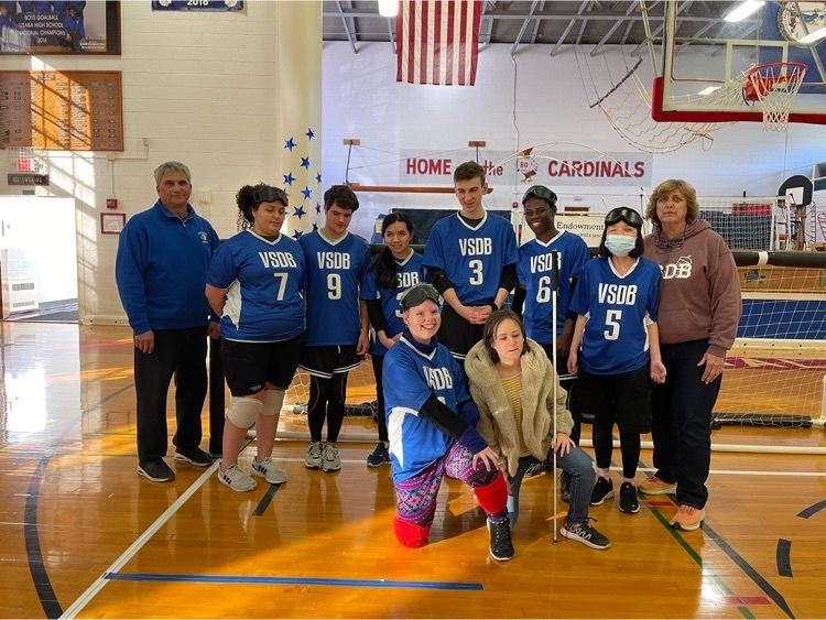 boys and girls Goalball teams with coaches standing in front of the goal