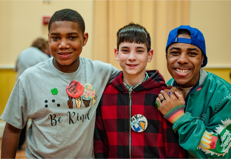 three male students standing together and smiling 