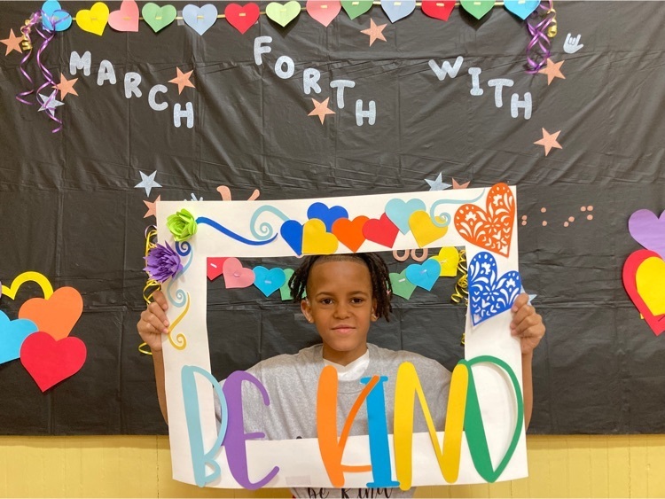 one student poses with the be kind photo frame 