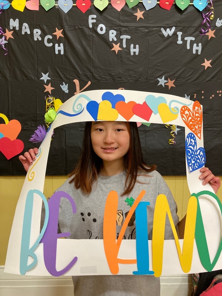 one student poses with the be kind photo frame