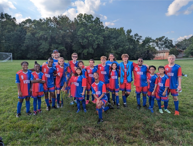 VSDB deaf soccer team on a grass field with soccer uniforms on. uniforms are red on one side and blue on the other with VSDB across the chest