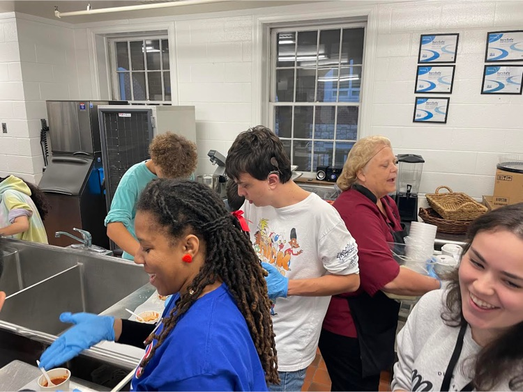students and staff in the kitchen working