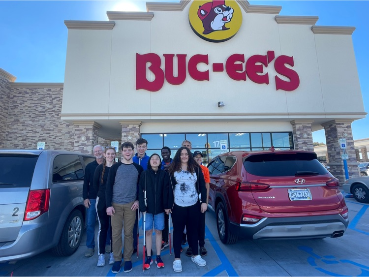 Goalball teams standing in front of a bucees store
