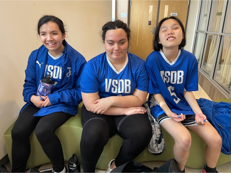 three VSDB girl goalball players sitting on a bench. 